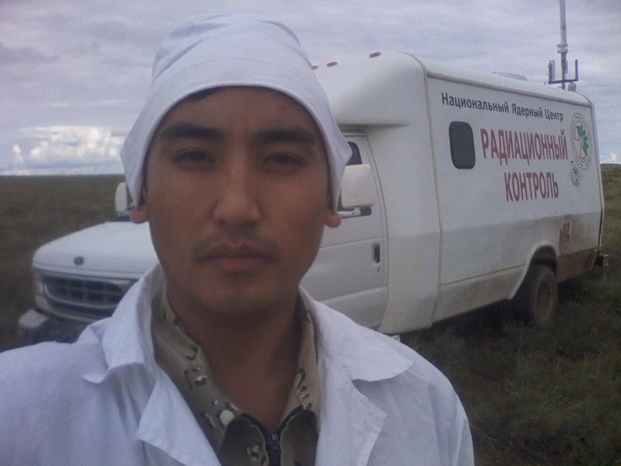 Специалист рядом с автомобилем с надписью «Радиационный контроль»